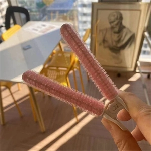 Close-up of pink plastic hair root clips with fine teeth for styling and volume