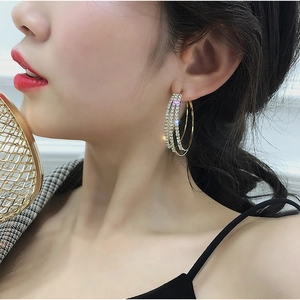 Elegant multi-layer gold hoop earrings with white zircons on female model