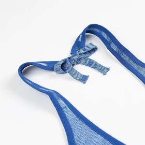 Détail du tissu en maille rayé bleu avec un nœud papillon décoratif sur le devant