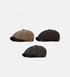 Three British style newsboy caps in khaki and grey chevron wool showing fabric texture