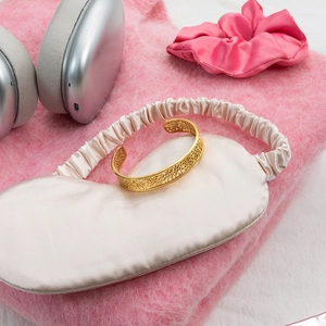 Détail d'un bracelet ouvert en acier inoxydable plaqué or 18K avec motif dentelle ajouré