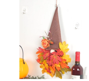 Detail of autumn gnome wall hanging with orange maple leaves and pointed brown hat