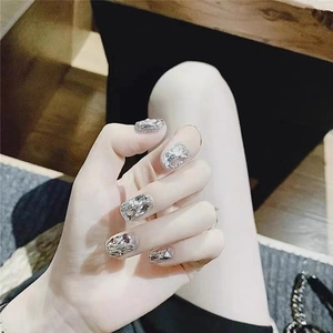 Detail view of silver handmade press-on nails with glitter and rhinestone embellishments