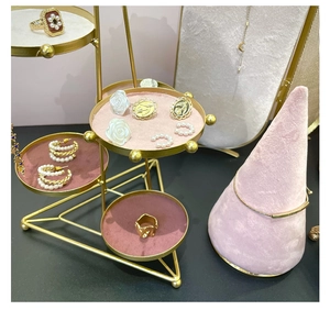 Top view of pink velvet tiered jewelry display with golden metal frame and ring cone