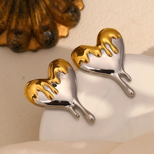 Detailed view of melting heart earrings featuring two-tone gold and silver fluid design