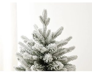 Close-up of artificial flocked Christmas tree top with realistic snow effect detail
