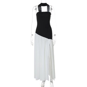 Detail of elegant black halter top with white pleated skirt and side slit on mannequin