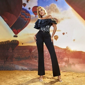 Détail du haut noir à volants et dentelle avec un pantalon évasé à taille haute élégant