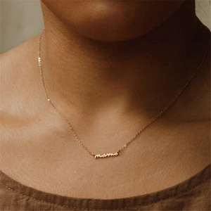 Dettaglio della collana con pendente MAMA in argento sterling S925 dorato su modella