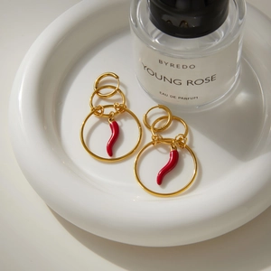 Luxurious gold stainless steel hoop earrings with vibrant red chili pendants on white tray