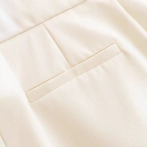Chic cream high-waisted trousers featuring a precision welt pocket and premium fabric texture