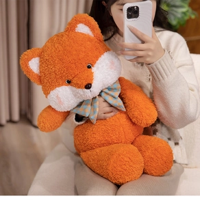 Close-up of a large orange plush fox with a checkered bow tie in a home setting
