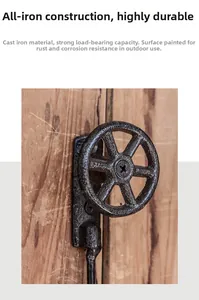 Gros plan du crochet de roue de vanne en fonte noire industrielle sur fond de bois vintage