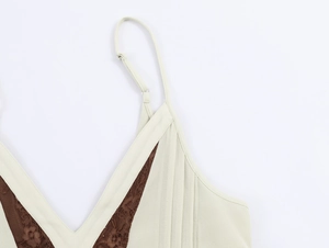 Detail of ivory v-neck mini dress featuring dark brown floral lace and ruched pleats