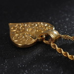 Close-up of golden heart pendant with hollow patterns on a twisted rope chain