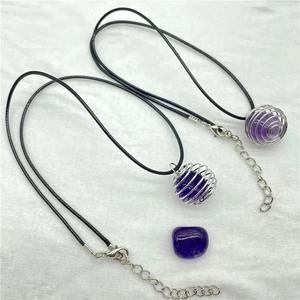 Detail of amethyst crystal necklaces with silver spiral cages and black wax cords