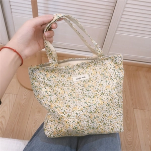 Dettaglio della borsa da pranzo in tela a fiori con zip ed etichetta simple wish