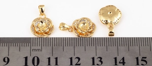 Macro detail of micro-pave flower charm with golden finish and sparkling zircon stones