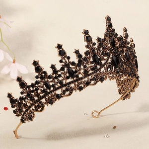 Detail of vintage bronze crown with intricate leaf patterns and black rhinestones