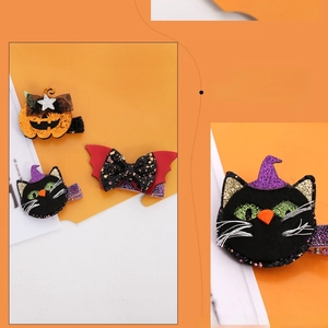 Detail of Halloween hair clips set featuring sequined pumpkin, bat bow and black cat designs