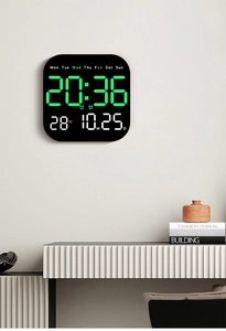 Detail of black digital wall clock displaying time, date, week, and temperature on a white wall