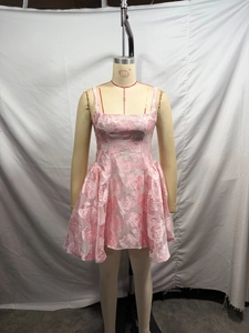 Détail d'une robe rose sans manches à fleurs avec texture brillante et style court élégant