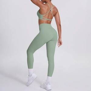 Détail de l'ensemble de yoga vert sauge avec brassière croisée et legging taille haute