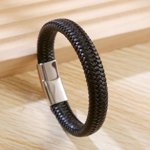 Macro detail of hand-woven leather bracelet with polished stainless steel magnetic clasp