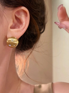 Detail of 18k gold plated brushed metal stud earring with sparkling zircon star inlay