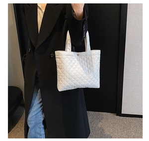 Dettaglio di borsa tote trapuntata bianca con motivo a rombi e chiusura con bottone
