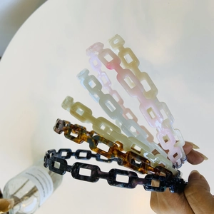 Detail of five acetate geometric chain headbands in tortoiseshell and solid colors