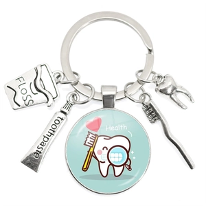 Creative dental themed keychain with toothbrush toothpaste and tooth charms on white background