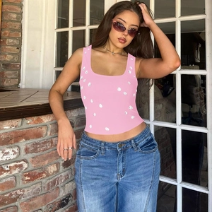 Detail of pink slim fit U-neck tank top with white beaded accents on a female model