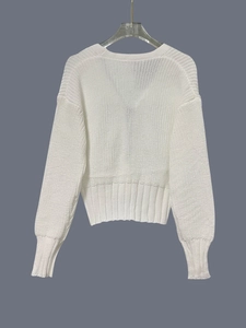 Vista posteriore di un cardigan bianco lavorato a maglia con fiocco decorativo