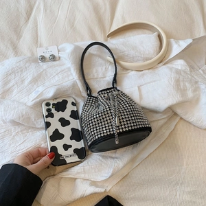 Sparkling black rhinestone bucket bag with drawstring closure on white shirt display