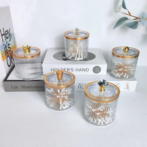 Luxurious glass cotton swab holders with gold lids and variety of handle shapes