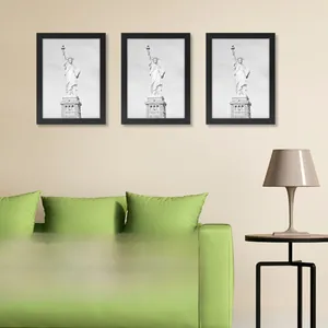 Three-piece black minimalist wooden poster frames mounted vertically on a beige wall