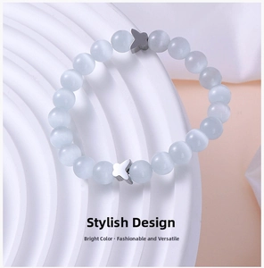 Detailed macro of a light blue cat eye stone beaded bracelet with silver butterfly charms