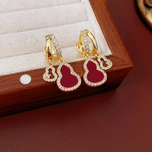 Detail of gold-plated gourd earrings with red gemstones and clear zircon inlay