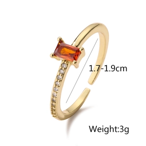Detail shot of gold adjustable ring with orange zircon and white accents, 1.7-1.9cm inner diameter