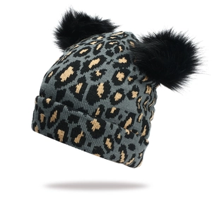 Women's leopard print knitted beanie featuring double faux fur pom-poms and warm cuff