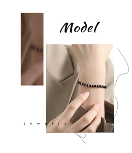 Dettaglio del bracciale con perline di pietra nera e sfere in acciaio inossidabile