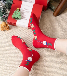Close-up of festive red Christmas socks with Santa Claus patterns in a holiday setting