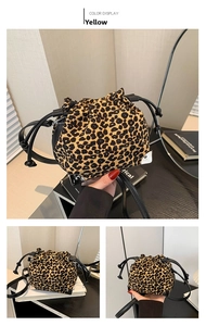 Detailed close-up of leopard print drawstring bucket bag with black leather base and straps
