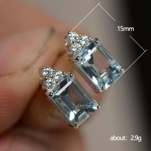 Light blue topaz zircon stud earrings with silver metal base and diamond accents