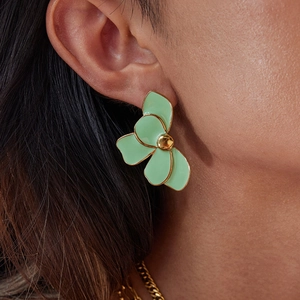 Detail of 18K gold stainless steel flower earrings with mint green enamel on model