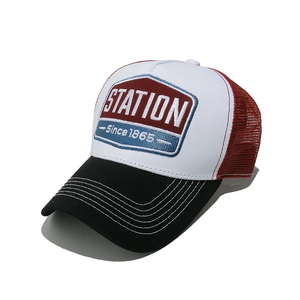 Detail of vintage trucker hat with STATION embroidery patch and breathable red mesh