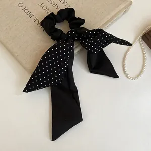 Polka dot black satin bow scrunchie with long ribbons for elegant hairstyling