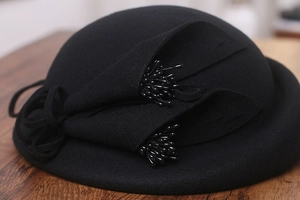 Détail du chapeau en feutre de laine avec décor floral et perles brillantes noires