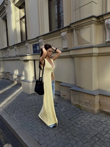 Pale yellow sleeveless long knitted cardigan with deep V-neck and high side slits